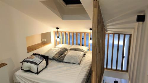 une chambre avec un lit avec des draps blancs et des oreillers dans l'établissement Hypercentre lamartine 505, à Nice