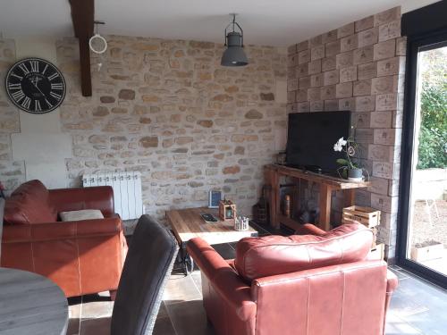 a living room with leather furniture and a tv at Oclos du RhuisO in Rhuis