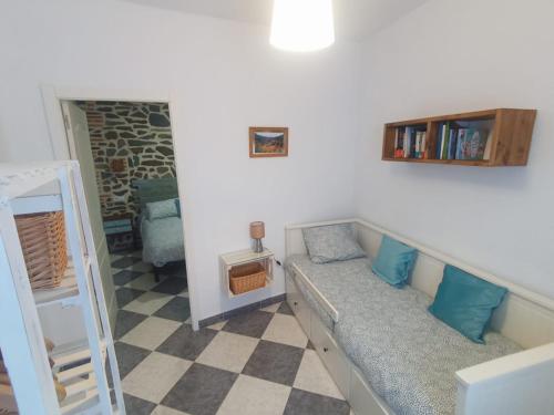 Habitación con sofá y estante para libros en Casa Monte Los Peñasquitos, en Cazalla de la Sierra