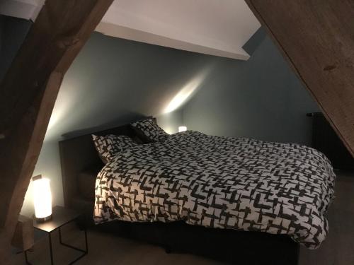a bedroom with a bed and two lamps in a attic at La grange de thoricourt in Thoricourt