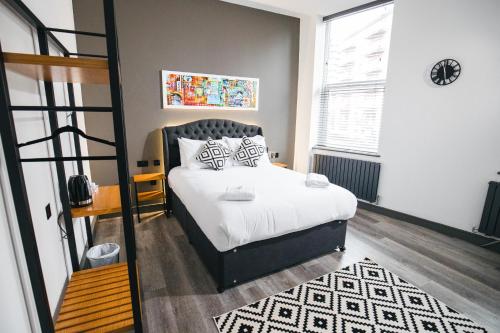 a bedroom with a bed with white sheets and pillows at Black Lion Hotel Manchester in Manchester
