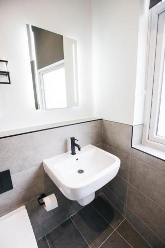 a bathroom with a white sink and a mirror at Black Lion Hotel Manchester in Manchester
