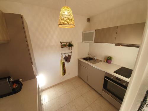 une cuisine avec un évier et une cuisinière four supérieur dans l'établissement Le Cézanne - Climatisé avec grande terrasse, à Gréoux-les-Bains