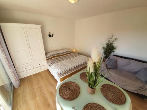 Kleines Zimmer mit einem Bett und einem Tisch in der Unterkunft Le Cézanne - Climatisé avec grande terrasse in Gréoux-les-Bains
