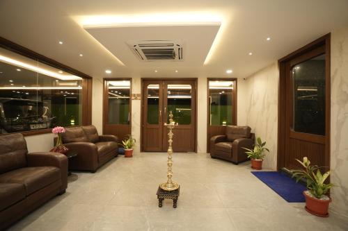 a lobby with couches and chairs and a table at GRAND GANPAT in Vellore