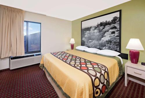 a hotel room with a large bed and a window at Super 8 by Wyndham Metropolis in Metropolis