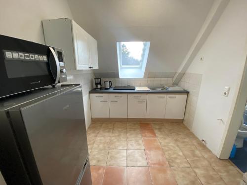 een kleine keuken met een koelkast en een raam bij Othman Appartements Groß Buchholzer Straße 16a in Hannover