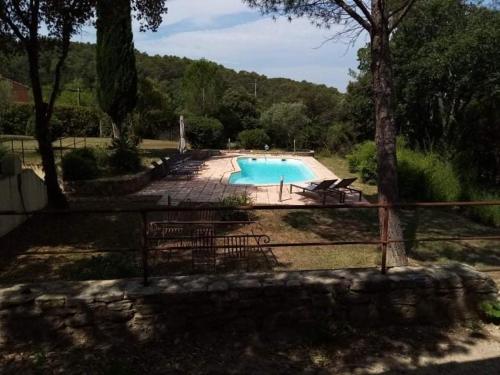 a swimming pool with chairs and a fence around it at Comorebi Provence in Entrecasteaux