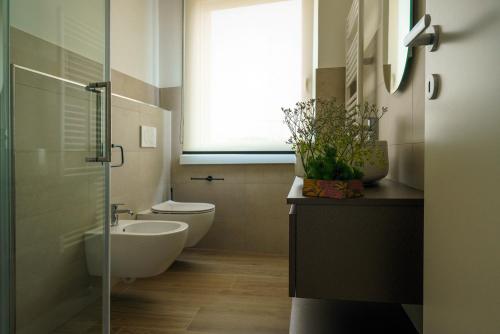 a bathroom with a toilet and a sink and a window at Residenza Ca'Fe in Treviso