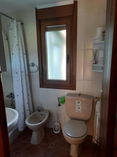 a bathroom with a toilet and a sink and a window at Apartamento Enzo in La Franca