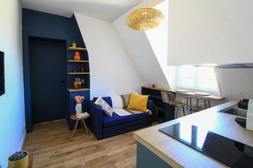 Il comprend une cuisine et un salon doté d'un canapé bleu. dans l'établissement Charming 2-Room 21m Comfort Sacré-Cœur View, à Paris
