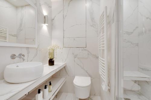 une salle de bain blanche avec un lavabo et des toilettes dans l'établissement Charming apartment - 2BR-6P -In the heart of Paris, à Paris
