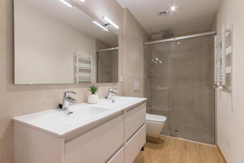 a white bathroom with a sink and a shower at Nuevo y Luminoso en Plaza Moyua in Bilbao