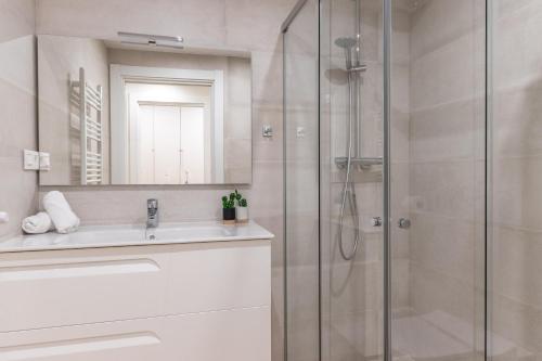 a bathroom with a glass shower and a sink at Nuevo y Luminoso en Plaza Moyua in Bilbao