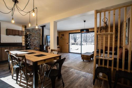 une cuisine et une salle à manger avec une table et des chaises en bois dans l'établissement Chalet Le Loup Blanc, aux Orres