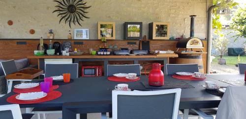 uma mesa com pratos vermelhos numa cozinha em Gîte et chambres d'hôtes Le Chêne Billault em Pouant