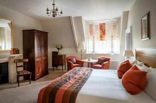 a hotel room with a large bed and a large window at Ettington Park Hotel, Stratford-upon-Avon in Stratford-upon-Avon