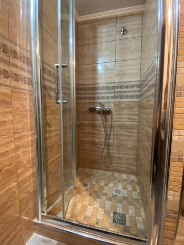 a shower with a glass door in a bathroom at The only luxurious apartment in the center of town in Kilkís