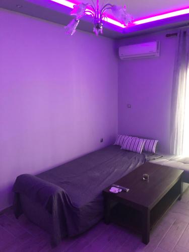 a bedroom with a large bed with purple lights at The only luxurious apartment in the center of town in Kilkís