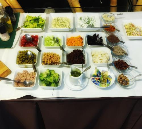 a table topped with bowls of different types of food at Arena Hotel Spa & Wellness in Tychy