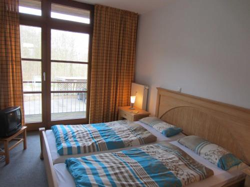 WittenbeckにあるFerienwohnung Sonnenwieseのベッド2台と窓が備わるホテルルームです。