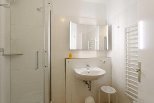 ein weißes Bad mit einem Waschbecken und einer Dusche in der Unterkunft Ferienwohnung Rebecca in Kühlungsborn