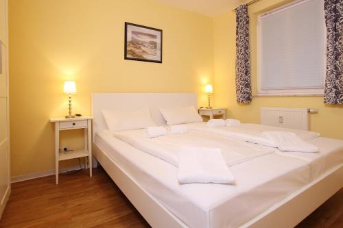 ein großes weißes Bett in einem Zimmer mit Fenster in der Unterkunft Ferienwohnung Meeresblick in Kühlungsborn