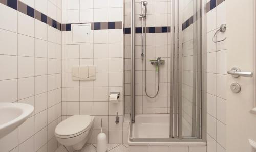 a bathroom with a shower with a toilet and a sink at Ferienwohnung Parkblick Nr. 25 in Kühlungsborn