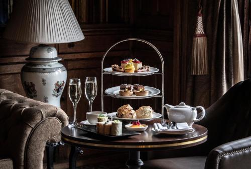 a table with three plates of pastries and wine glasses at Nutfield Priory Hotel & Spa in Redhill
