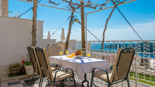
a dining room table with chairs and umbrellas at Apartments and Room Lora in Dubrovnik
