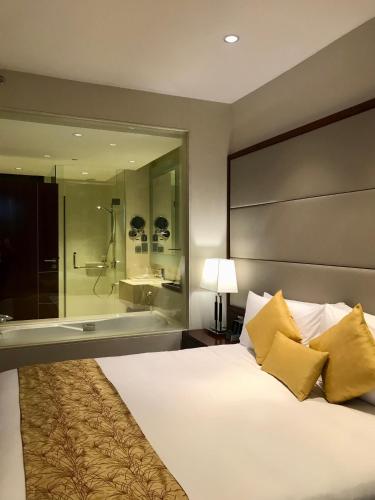 a bedroom with a large bed and a bath tub at Crowne Plaza Kochi by IHG in Cochin