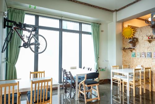 a room with a table and a bike hanging from the ceiling at 墾丁秋莊會館 附限量停車位 不保證有位置 無法事先預留 背包房無車位 預訂後記得加Line聯繫 in Hengchun