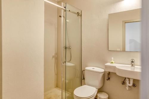 een badkamer met een douche, een toilet en een wastafel bij Apartamento Bajo 2 in Begur