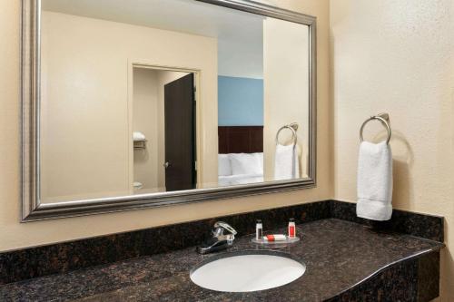 a bathroom with a sink and a large mirror at Luxe Studios Nashville Airport in Nashville