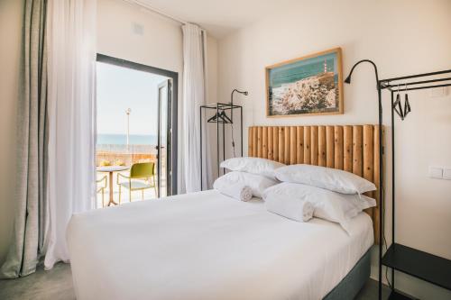 a bedroom with a bed with a view of the ocean at MUTE Hostel Porto Covo in Porto Covo