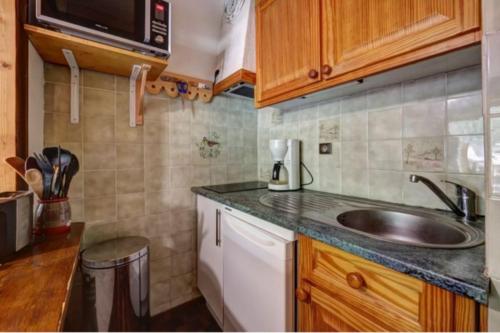 a small kitchen with a sink and a microwave at Studio with balcony in the center of the village in Le Grand-Bornand