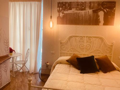 a bedroom with a bed with a black pillow on it at Granoro Gragnano B&B in Gragnano