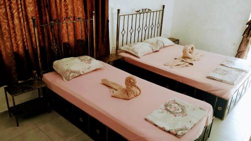 two beds with dolls on them in a room at Dracena Guesthouse in Ravda