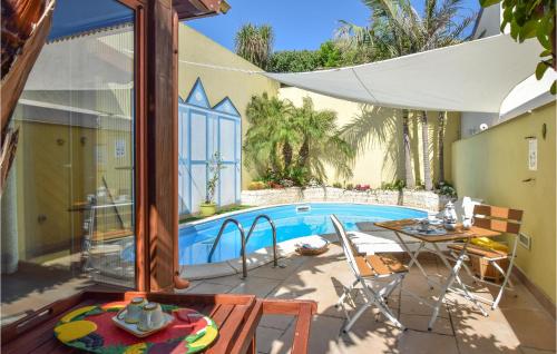 a patio with a pool and a table and chairs at Villa Cristiana in Scoglitti