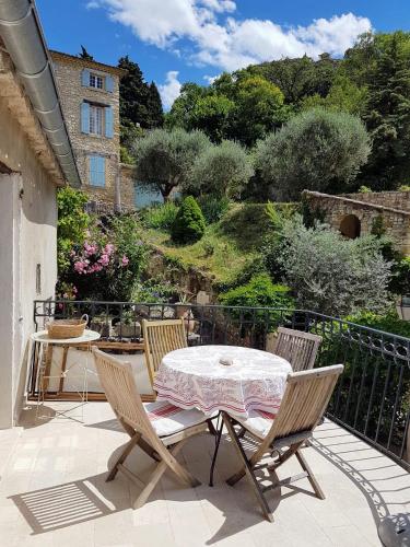 un patio avec une table et des chaises sur un balcon dans l'établissement Maison provençale en pierre naturelle à Gigondas, à Gigondas