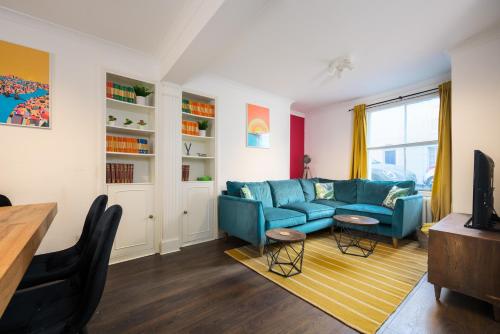 a living room with a blue couch and a table at Vibrant Spring Street with Garden in Brighton & Hove