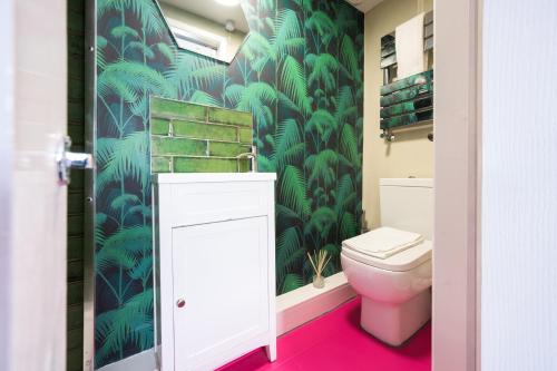 ブライトン＆ホーブにあるVibrant Spring Street with Gardenの緑豊かな緑の壁紙のバスルーム(トイレ付)