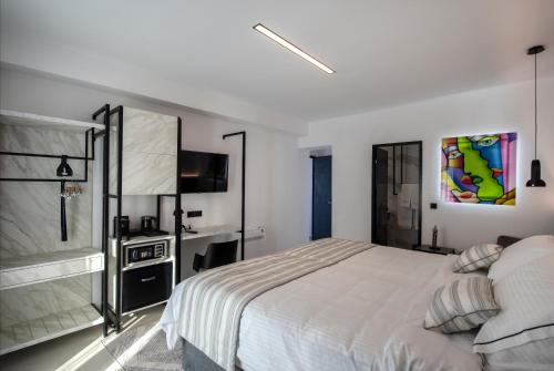 una camera bianca con letto e TV di Central Boutique Hotel by naoussa hills adults only a Naoussa