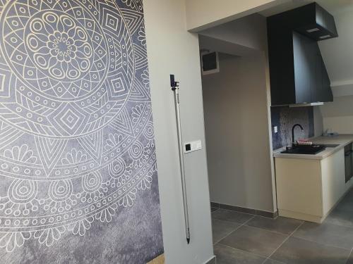a kitchen with a mandala mural on the wall at Kaposvár Apartman in Kaposvár