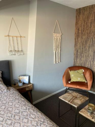 a room with a bed and a chair in a room at Bed and Breakfast Kik en Bun in Katwijk aan Zee