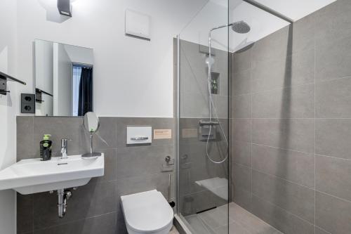 a bathroom with a shower and a toilet and a sink at limehome Rosenheim Gillitzerstraße in Rosenheim
