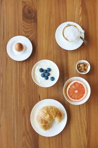 a table with plates of breakfast foods on it at Hotel am See in Hard