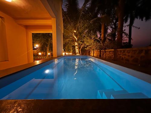 a swimming pool in a backyard at night at Villanta by Villament in Karjat