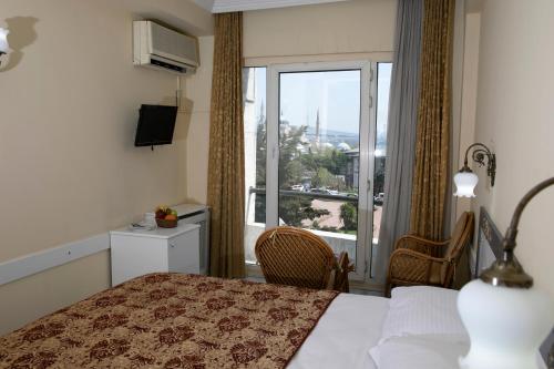 a hotel room with a bed and a large window at Hali Hotel in Istanbul