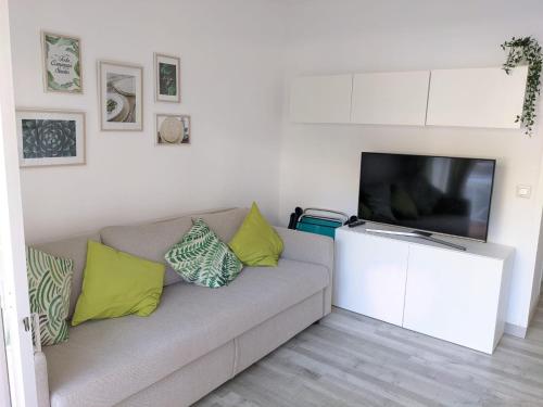 ein Wohnzimmer mit einem Sofa und einem Flachbild-TV in der Unterkunft Apartamento Cala del Pi in Platja  d'Aro